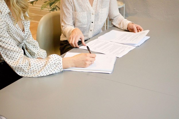 Two people working on legal documents at a table. 