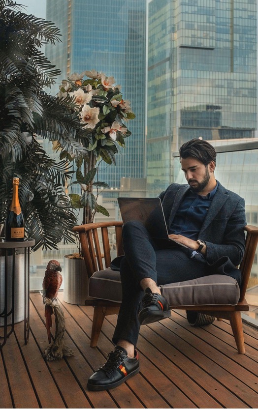 A well-dressed man works at a laptop. 