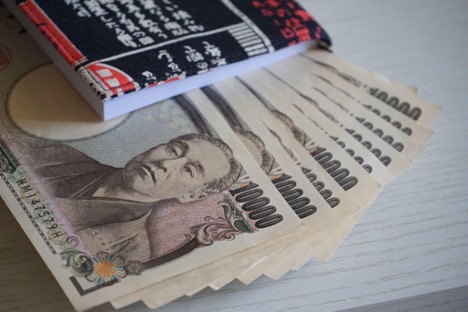 Several one thousand yen notes arranged neatly on a table.