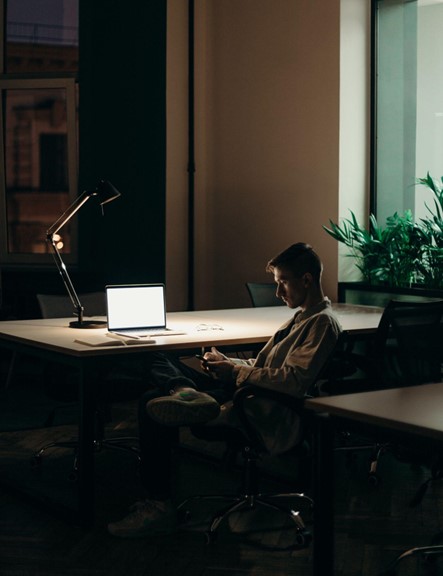 A man sits alone in a dimly lit office. Alternative Assets