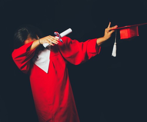 A graduate in a red cap and gown. 