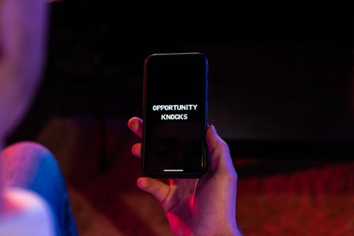 A smartphone screen showing the words ‘opportunity knocks’ Growing Investment Opportunity