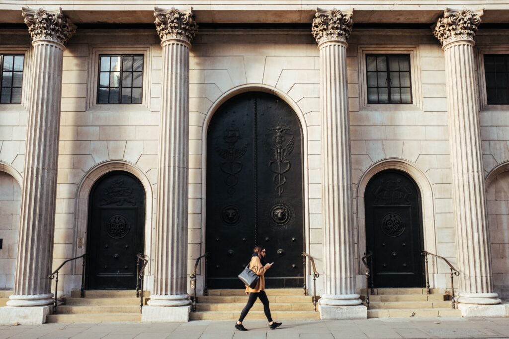 Bank of England with a woman walking in front of it