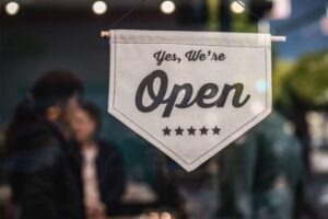 A business sign in a window showing they are open FDIC Insurance