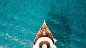 Aerial view of a luxury yacht in a bright blue sea wealth