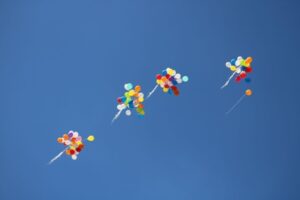 Multicolored balloons fly high in the blue sky. Alternative Investments