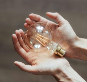 Hands holding a lightbulb for ‘The Rise of Alternative Investments for Family Offices- A Comprehensive Guide’