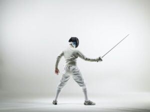 Person in white fencing gear with sabre for ‘Understanding The New Buzzword for Today’s Economy: Deflation’ deflation