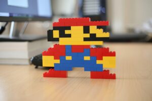 Interior, a Super Mario figurine made from lego sits atop a work desk, for “The 4 Key Features of Alternative Assets”