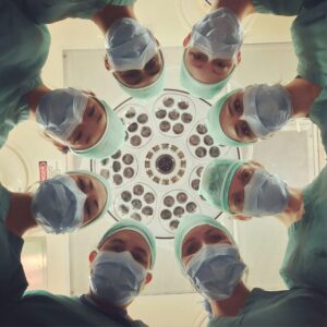 Several doctors in scrubs stand around an operating theater, for “How Family Offices Can Use Alternative Assets to Secure Wealth for Future Generations”