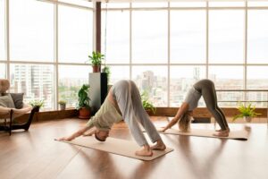 A side view of two people doing yoga in a beautiful wood paneled studio, for How to Use Passive Income to Grow Your Wealth in your 40’s 50’s 60’s and beyond